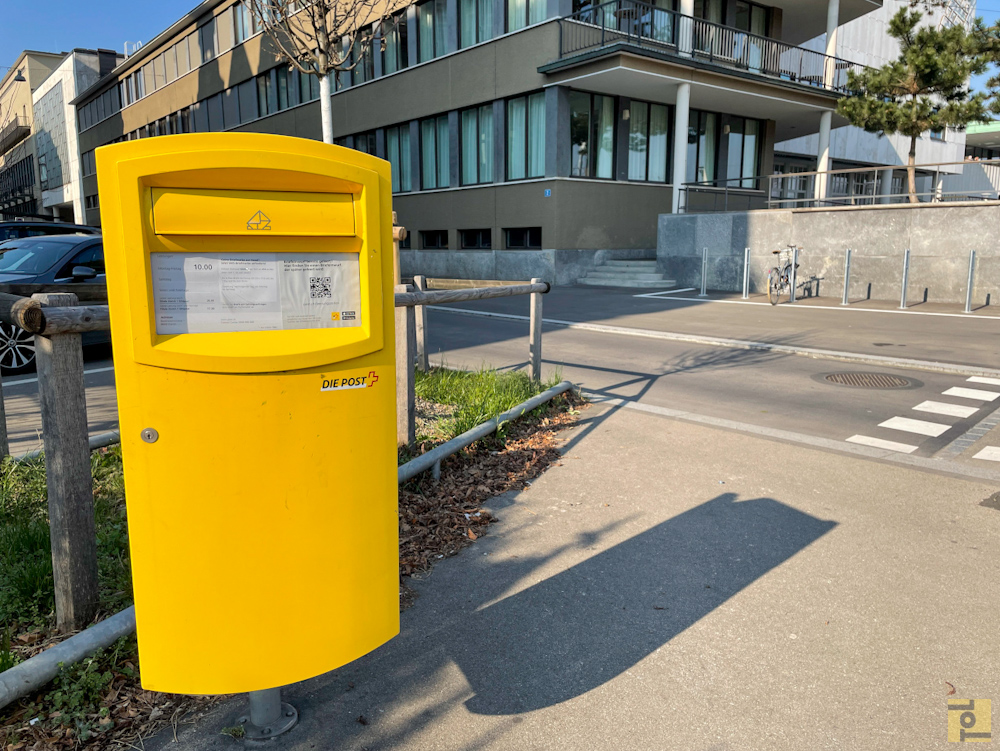 gelber Briefkasten um eine Postkarte aus der Schweiz zu versenden, in Zürich